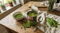 Boîte de petits pois ouverte avec pois frais éparpillés sur table en bois